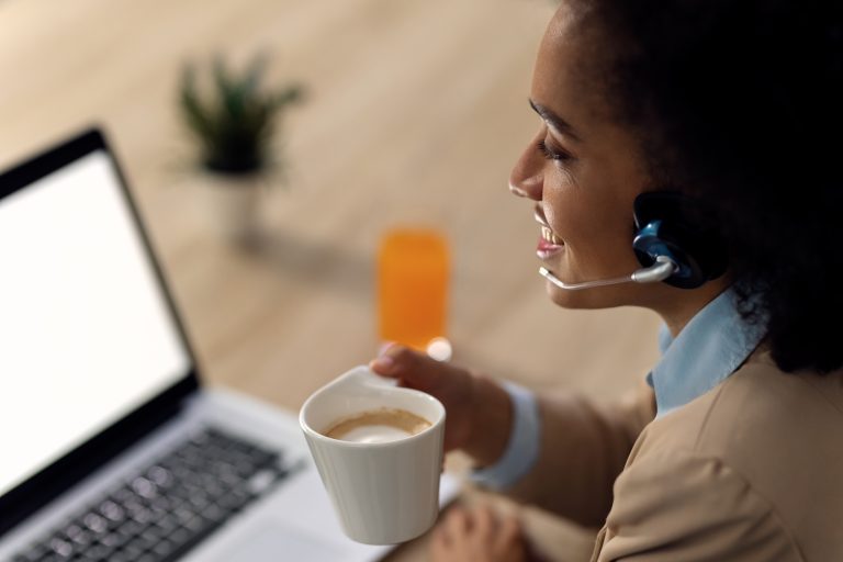 Happy African American businesswoman drinking coffee during conf